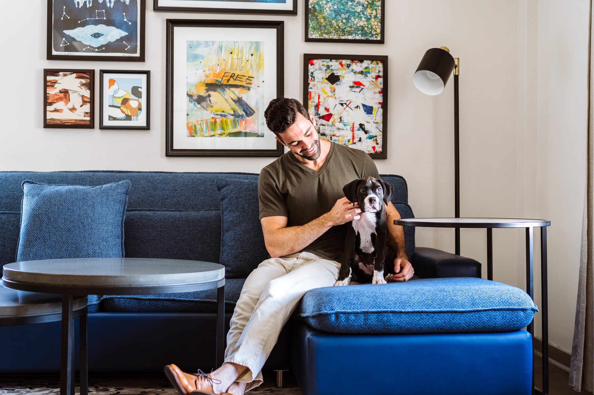 A man on a couch petting a dog.