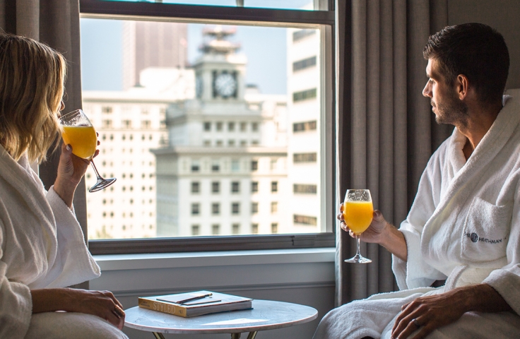 A couple in bath robes drinking mimosas